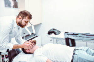 Chiropractor performing a spinal adjustment on a patient as part of treatment after a car accident.