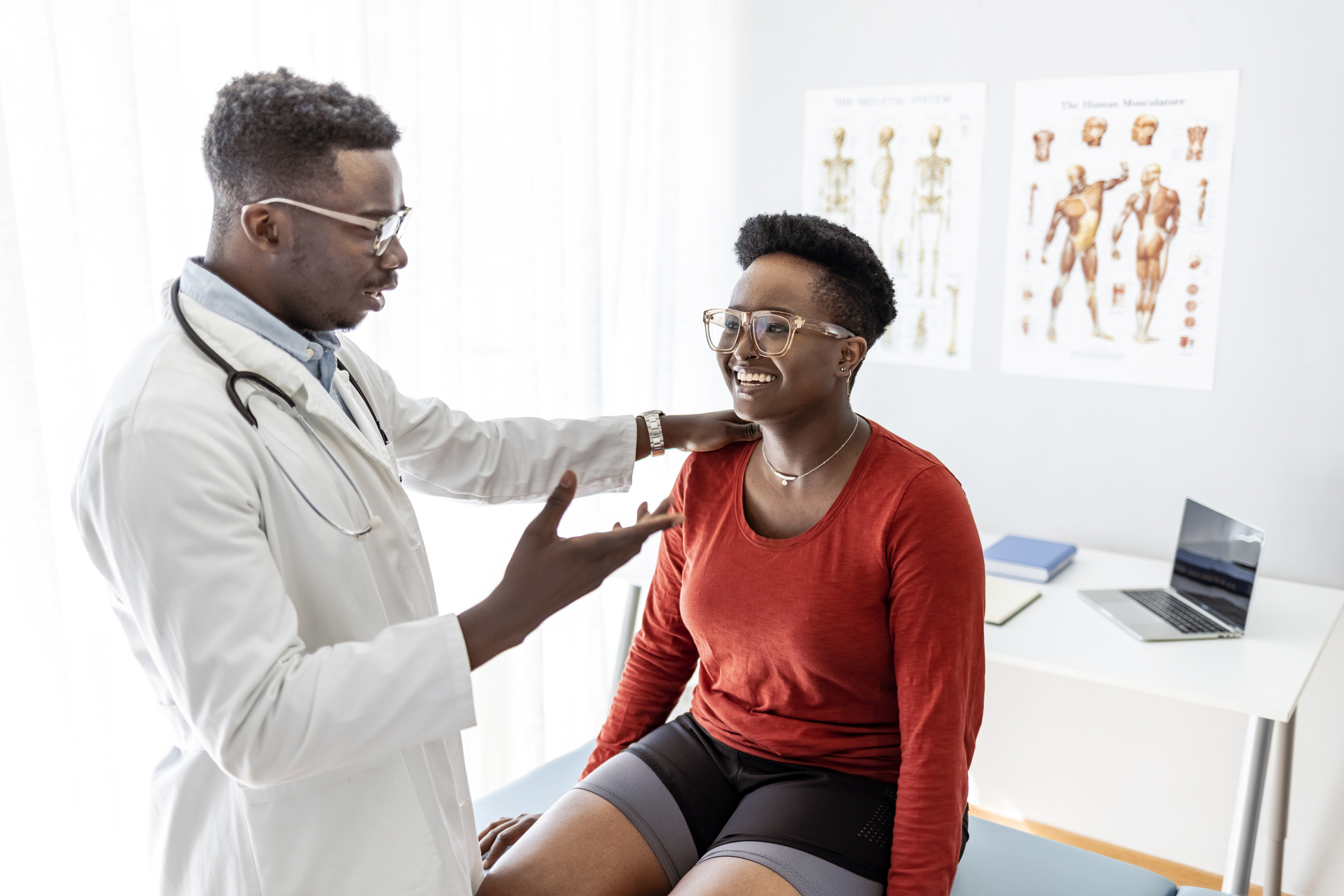 Pain management physician evaluating shoulder and neck pain during a clinical visit at a Tampa rehabilitation clinic