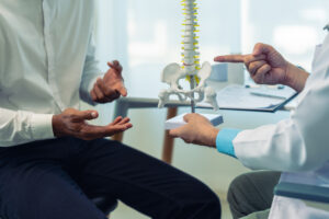 Provider explaining spinal anatomy and injection treatment options for neck and back pain after a car accident.