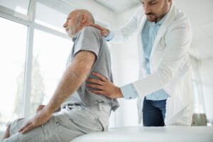 Healthcare provider evaluating a patient for sacroiliac joint pain after a car accident during a lower back and pelvic pain assessment.