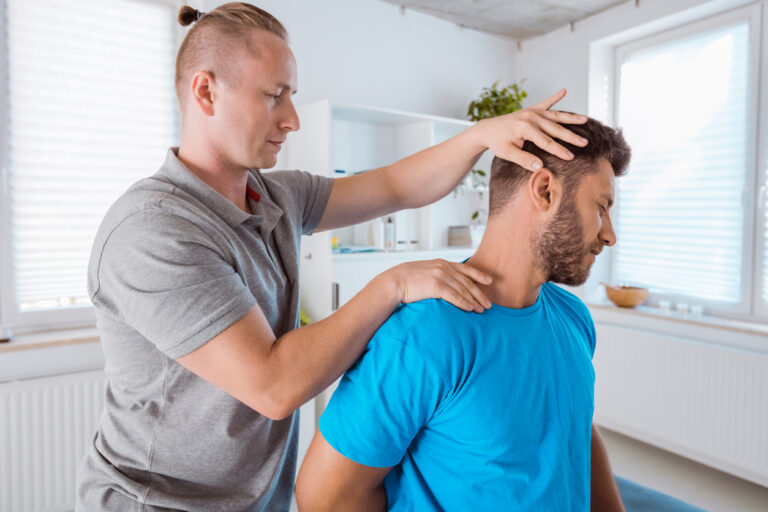 Healthcare provider evaluating cervical spine movement during a chiropractic appointment for post-accident injuries.