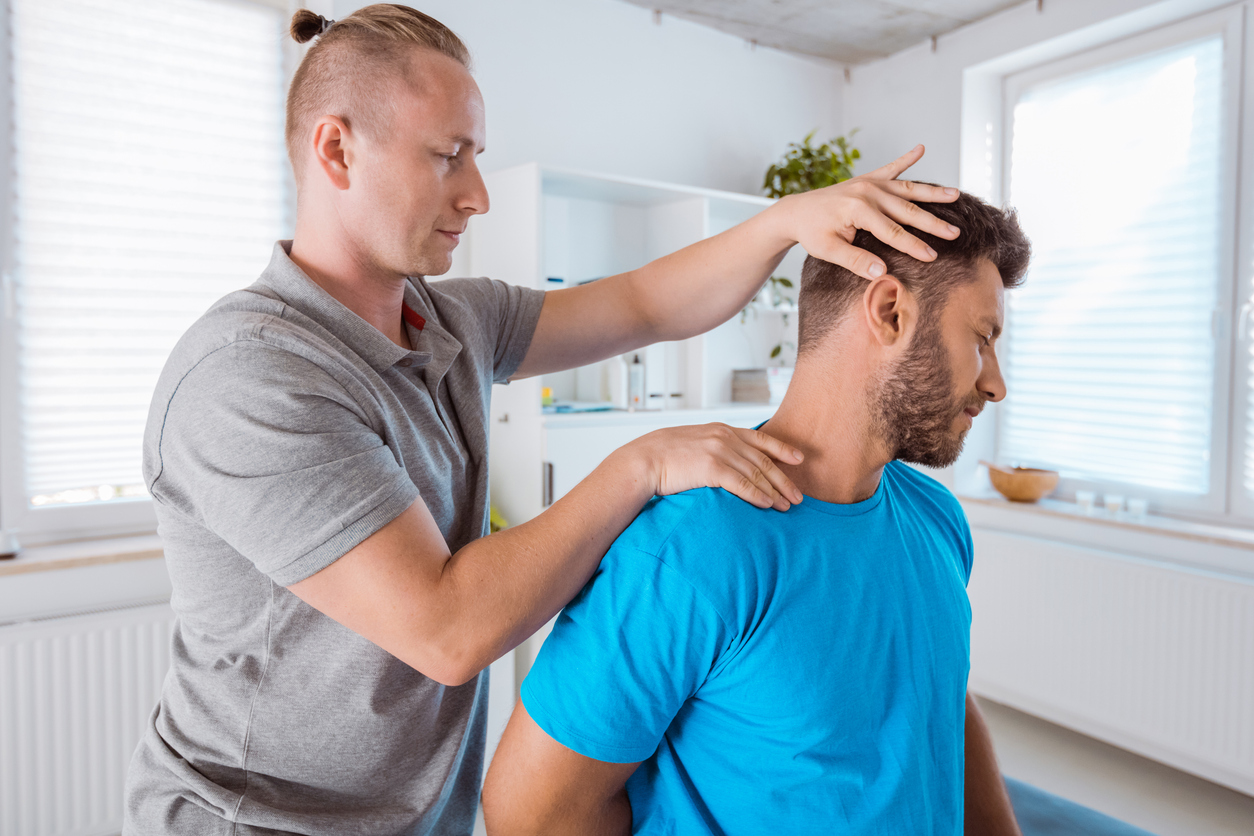 Healthcare provider evaluating cervical spine movement during a chiropractic appointment for post-accident injuries.