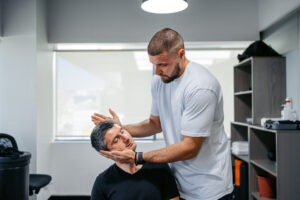 Chiropractor evaluating a patient's neck mobility during a post-car accident injury assessment.
