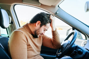 Driver seated in a vehicle after a collision, illustrating Florida auto accident injury care and PIP evaluation timing.