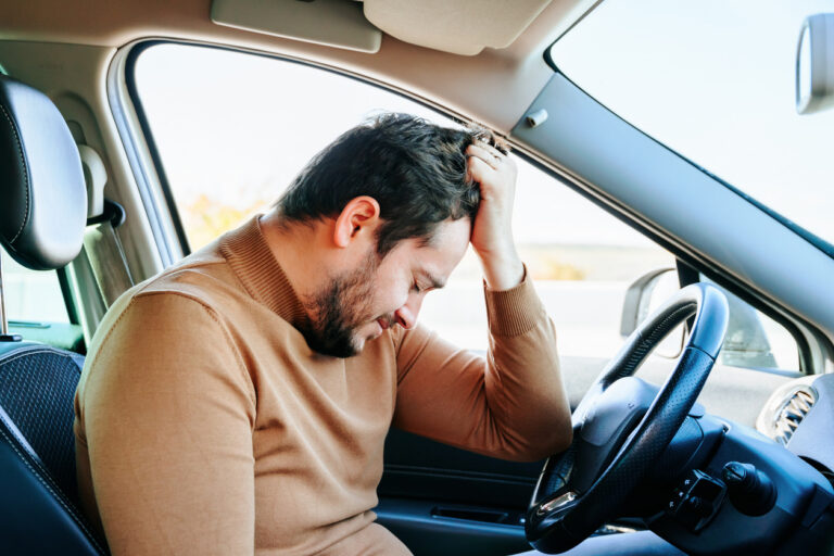 Driver seated in a vehicle after a collision, illustrating Florida auto accident injury care and PIP evaluation timing.