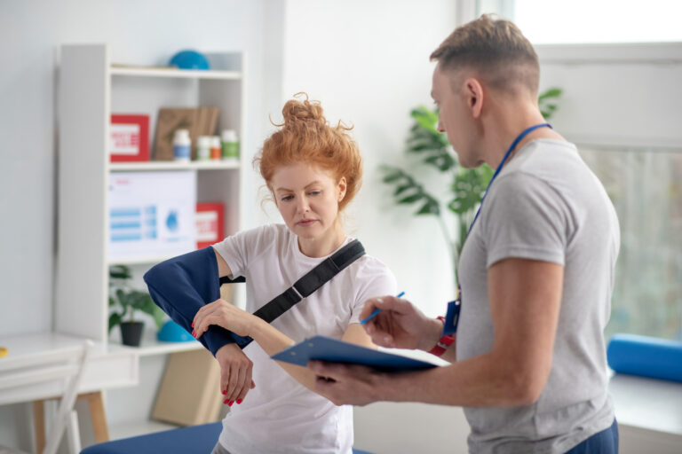 Patient wearing an arm sling during a physiotherapy evaluation after a car accident in Clearwater.