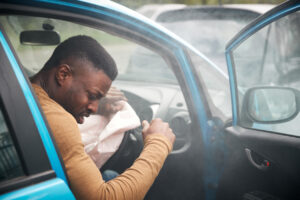 Driver inside a car after a collision, illustrating the need for a timely post-accident injury evaluation.
